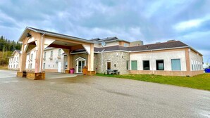 A two-story building with a covered entrance and a patio area. - Super 8 by Wyndham Hinton (Hinton)
