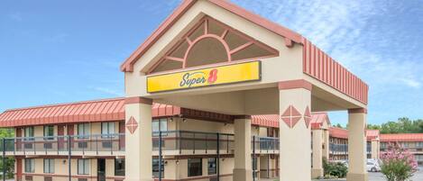 A Super 8 hotel with a red roof, beige exterior, and a signboard.