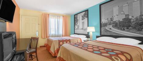 A hotel room with two beds, a TV, a desk with a chair, a window with curtains, and a cityscape painting on the wall.