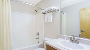 Un baño con bañera, inodoro, lavabo y espejo.
