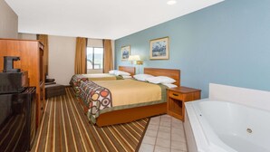 Habitación de hotel con dos camas, un refrigerador, una bañera y una ventana con cortinas.