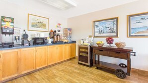 Una cocina con muebles de madera, una estación de café y una presentación de frutas.