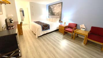 Een hotelkamer met een bed, een bureau, een stoel en een klein tafeltje.