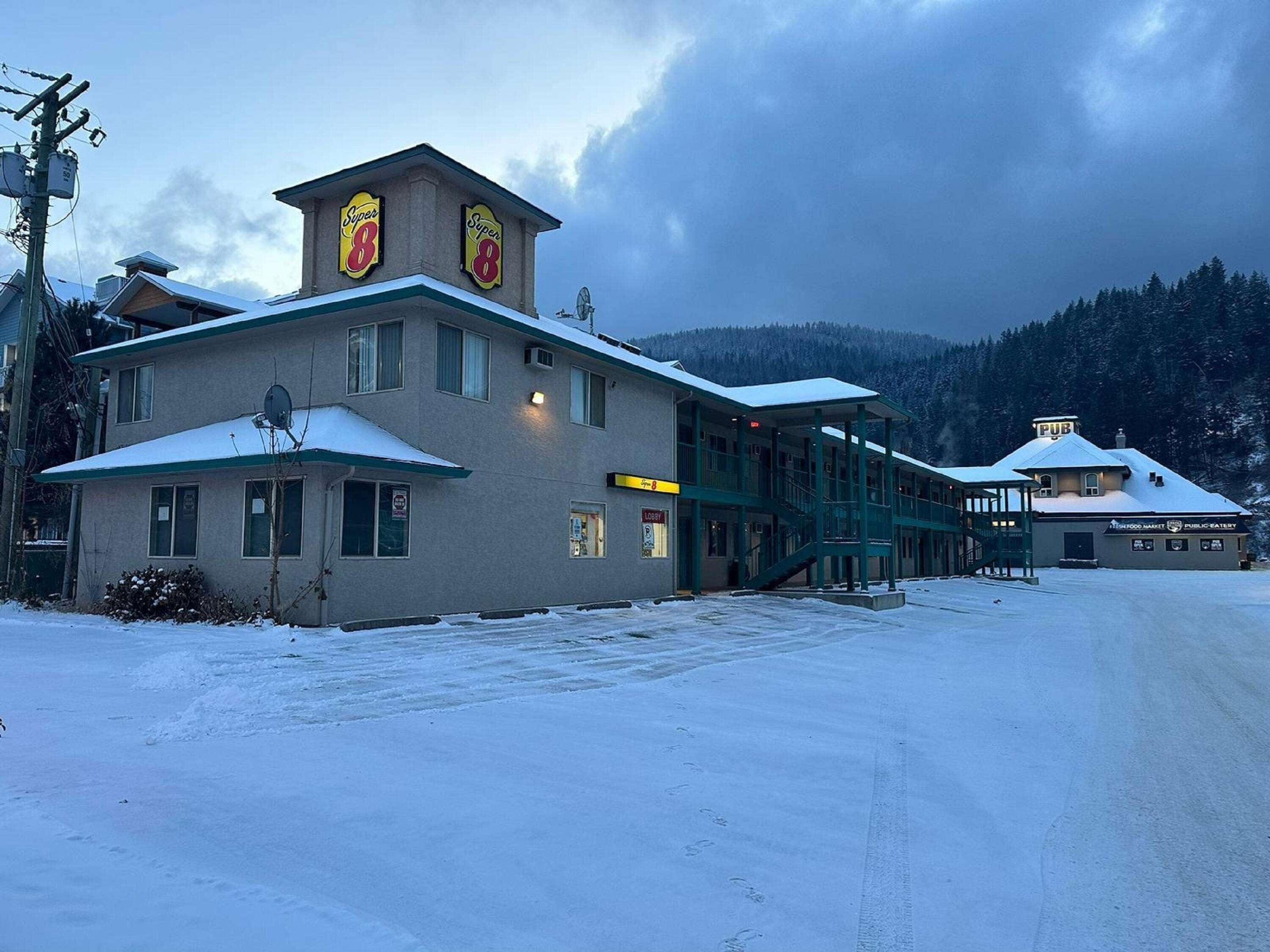 Un bâtiment avec une enseigne Super 8, un hall d’accueil et un pub.
