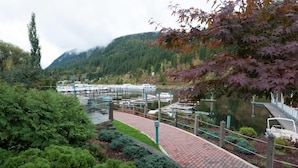 A riverfront area with a dock, boats, and a bridge.
