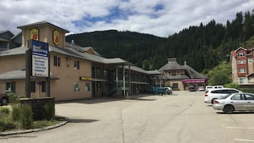 Experience the charm of Moose Mulligans, where a restaurant, pub, and patio await, surrounded by a scenic forested mountain backdrop.