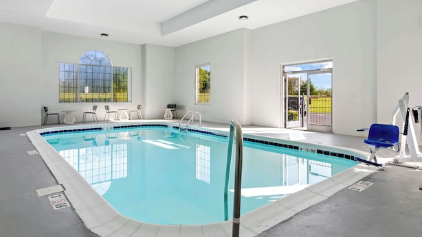 A large indoor swimming pool with clear blue water, surrounded by white walls and large windows. - Spark by Hilton Winston-Salem University (Winston-Salem)
