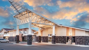 A hotel entrance with a modern design, featuring a large overhang and stone pillars. - Siding 16 Lodge (Wetaskiwin)