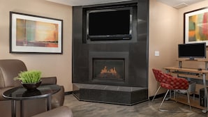 A modern living room with a fireplace, a flat-screen TV, and a comfortable seating area. - Super 8 by Wyndham Calgary Shawnessy Area (Calgary)