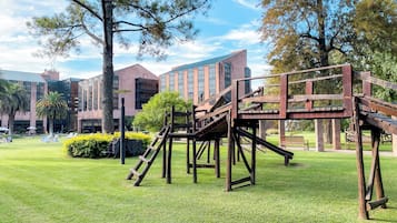 Relax in a serene outdoor space with a play structure, lounge chairs, and a tranquil atmosphere.