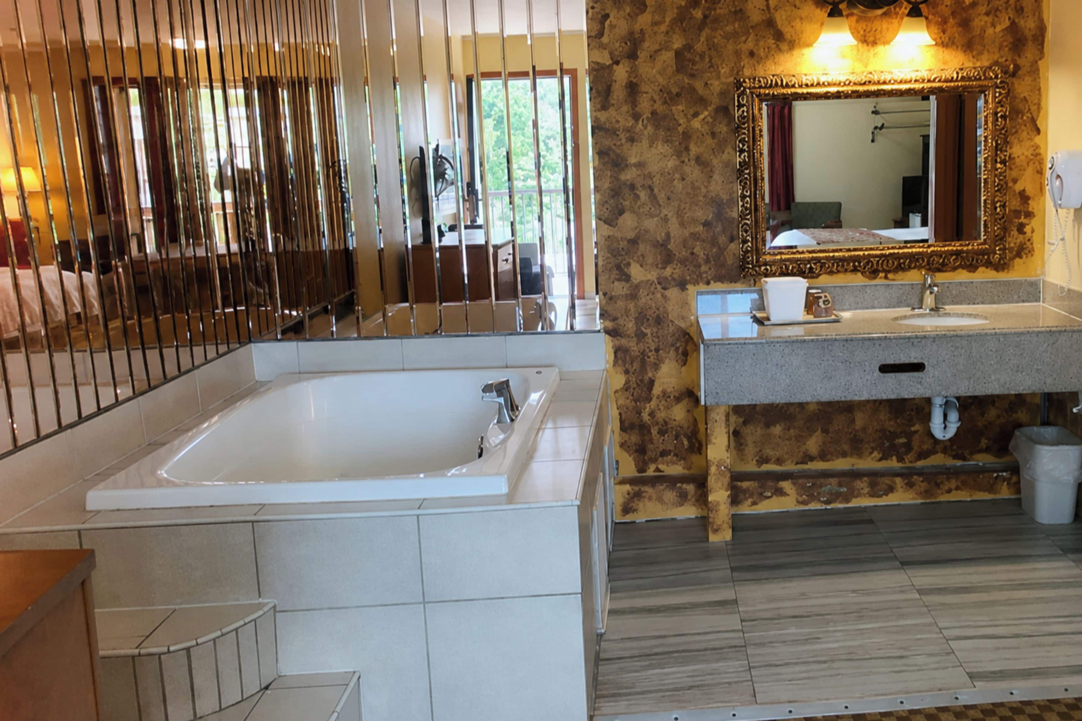 Un bagno con una vasca da bagno ampia, un lavandino e uno specchio.