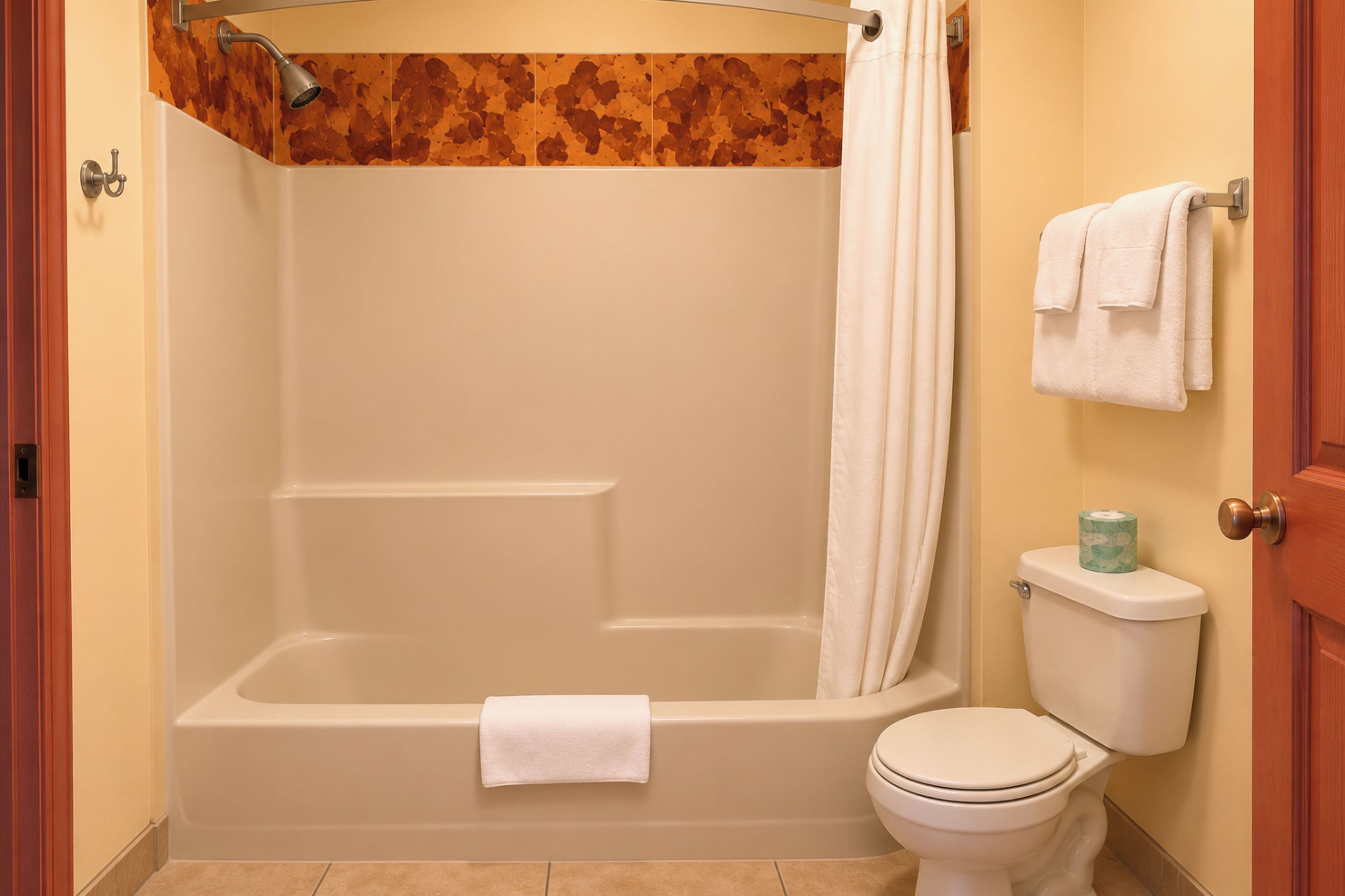 A bathroom with a bathtub, toilet, and a shower curtain.
