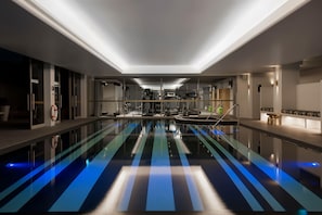 A modern indoor pool with a long, narrow design and blue lighting on the floor. - Ovolo Sydney Woolloomooloo, a Wyndham Hotel (Woolloomooloo)