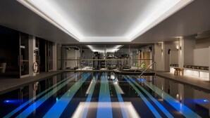 A modern indoor pool with a long, narrow design and blue lighting on the floor. - Ovolo Sydney Woolloomooloo, a Wyndham Hotel (Woolloomooloo)