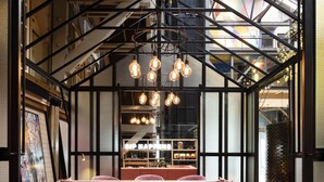 A modern interior with a high ceiling, exposed beams, and a seating area with sofas and chairs. - Ovolo Sydney Woolloomooloo, a Wyndham Hotel (Woolloomooloo)