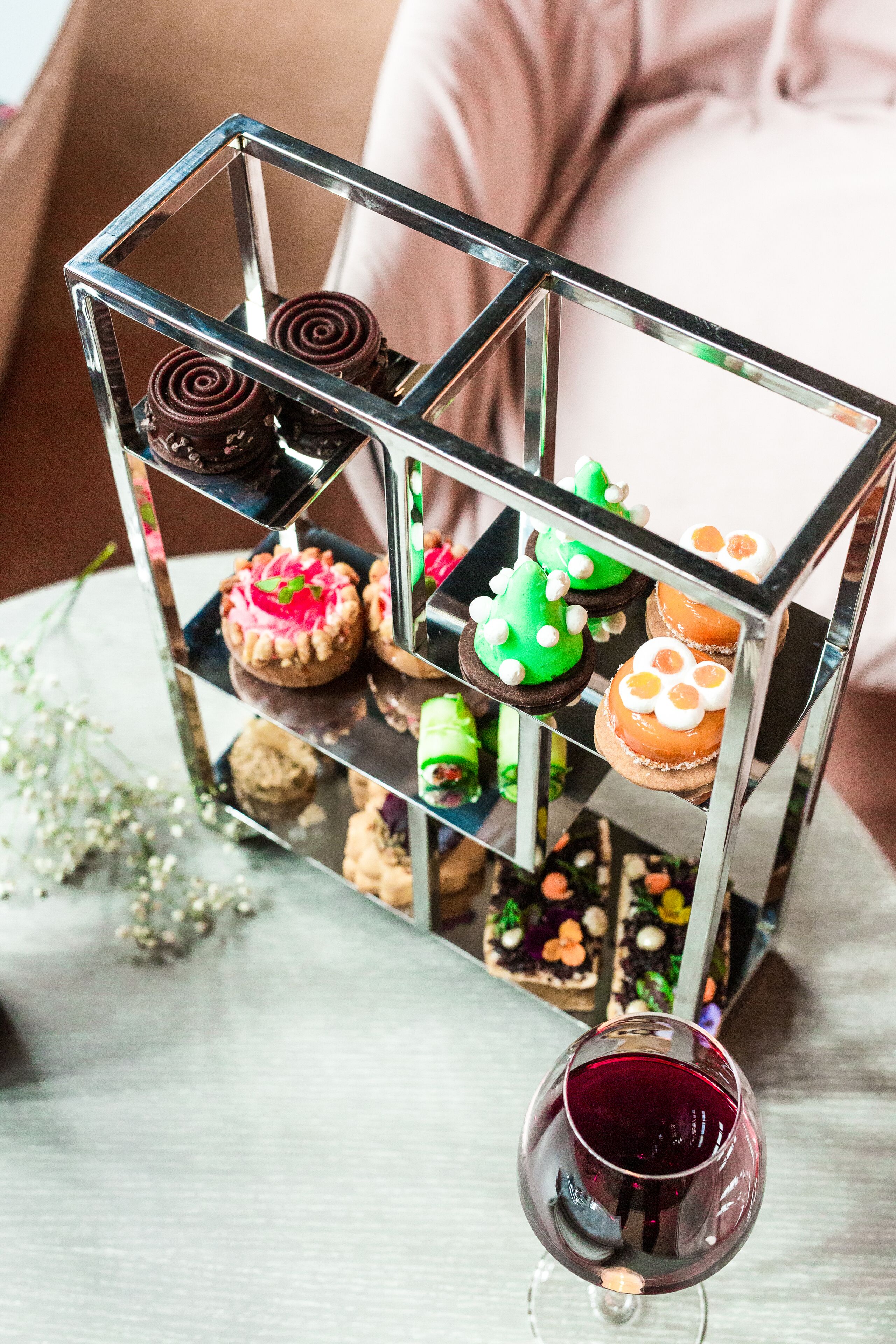 Una exposición de postres con diversos pasteles en un soporte de metal.