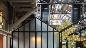 A modern lounge area with a glass partition, comfortable seating, and a central fire feature. - Ovolo Sydney Woolloomooloo, a Wyndham Hotel (Woolloomooloo)