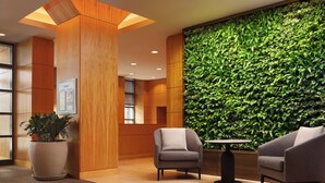 A lobby with wooden paneling, a green wall, and two armchairs. - The Westin St. Louis (St. Louis)