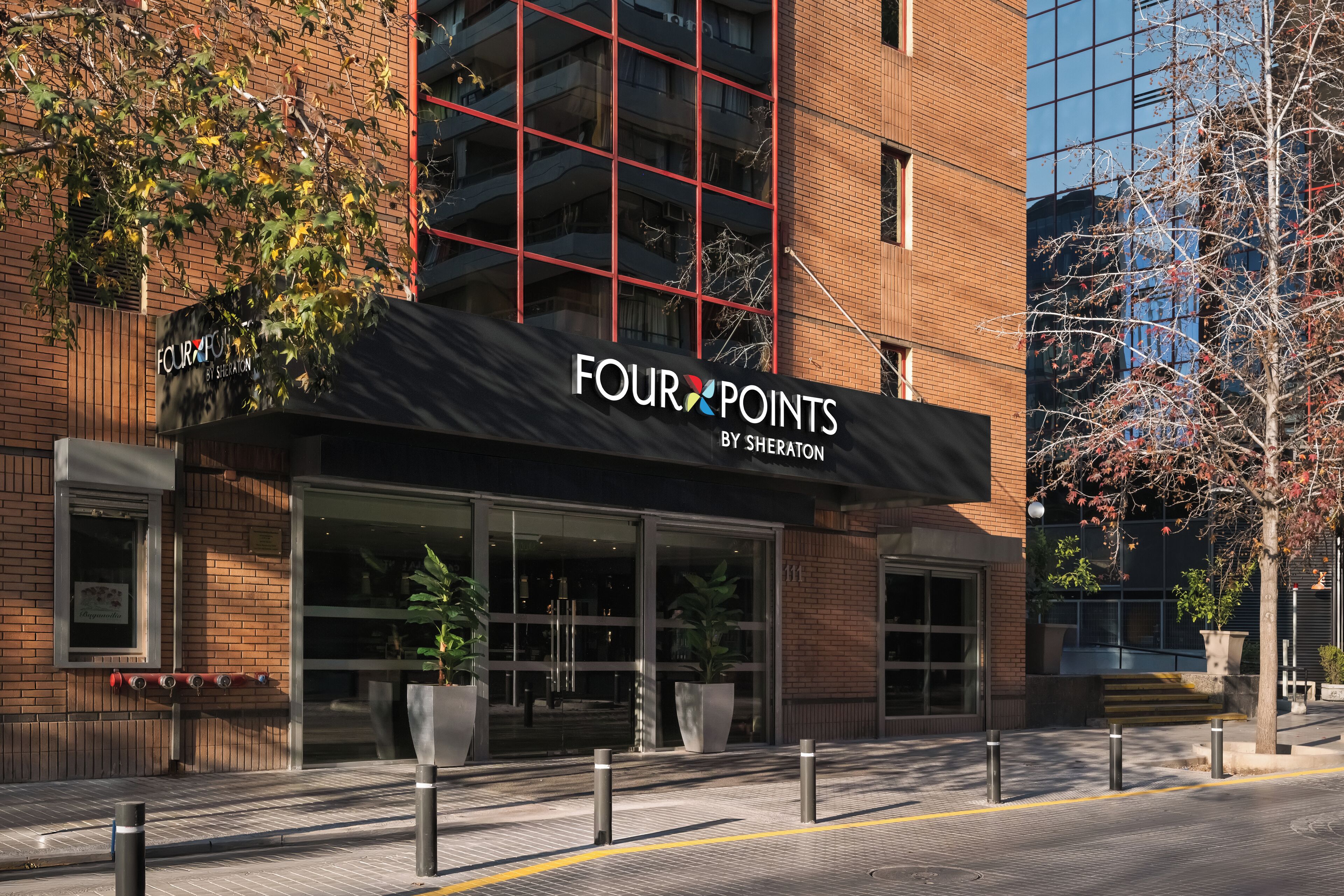 Un edificio con un cartel que dice "FOUR POINTS BY SHERATON" y ventanas amplias.