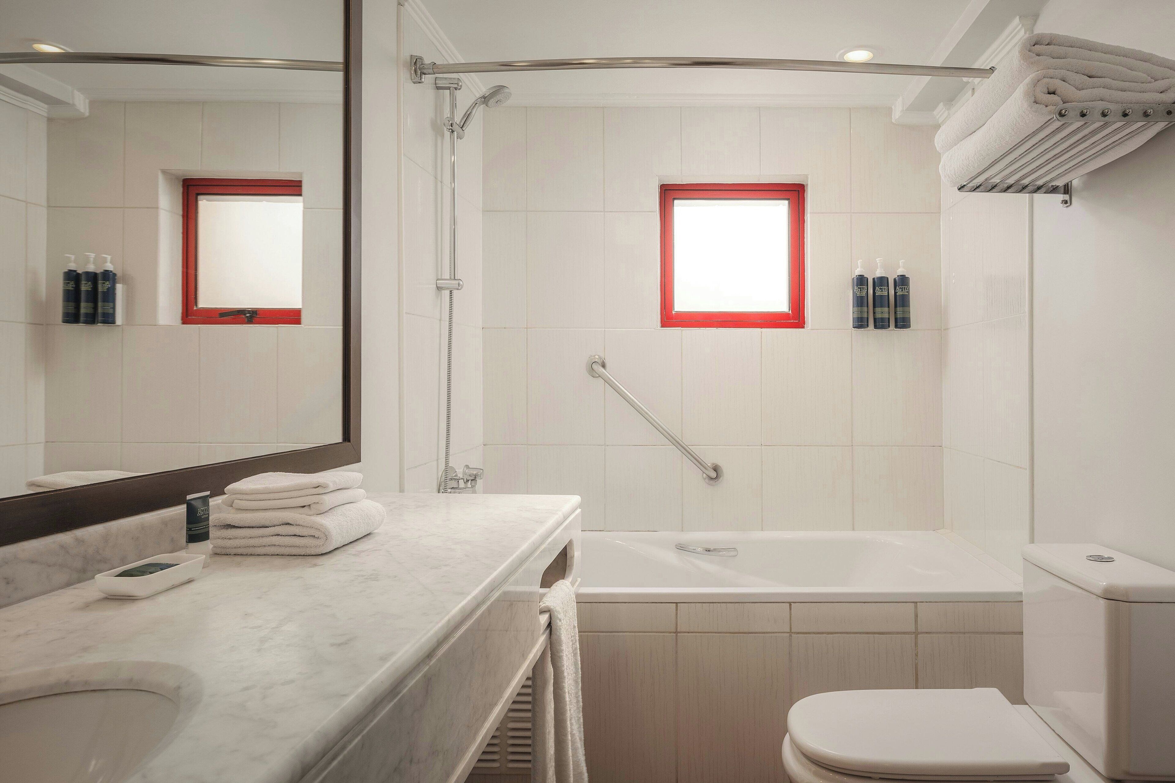 A modern bathroom with a bathtub, toilet, and sink.