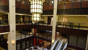 Un atrium à plusieurs niveaux, doté d’une verrière centrale, de nombreux étages et d’un escalier mécanique central.