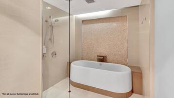 Une salle de bain moderne avec une baignoire sur pieds, une douche à parois de verre et un mur recouvert de carreaux.