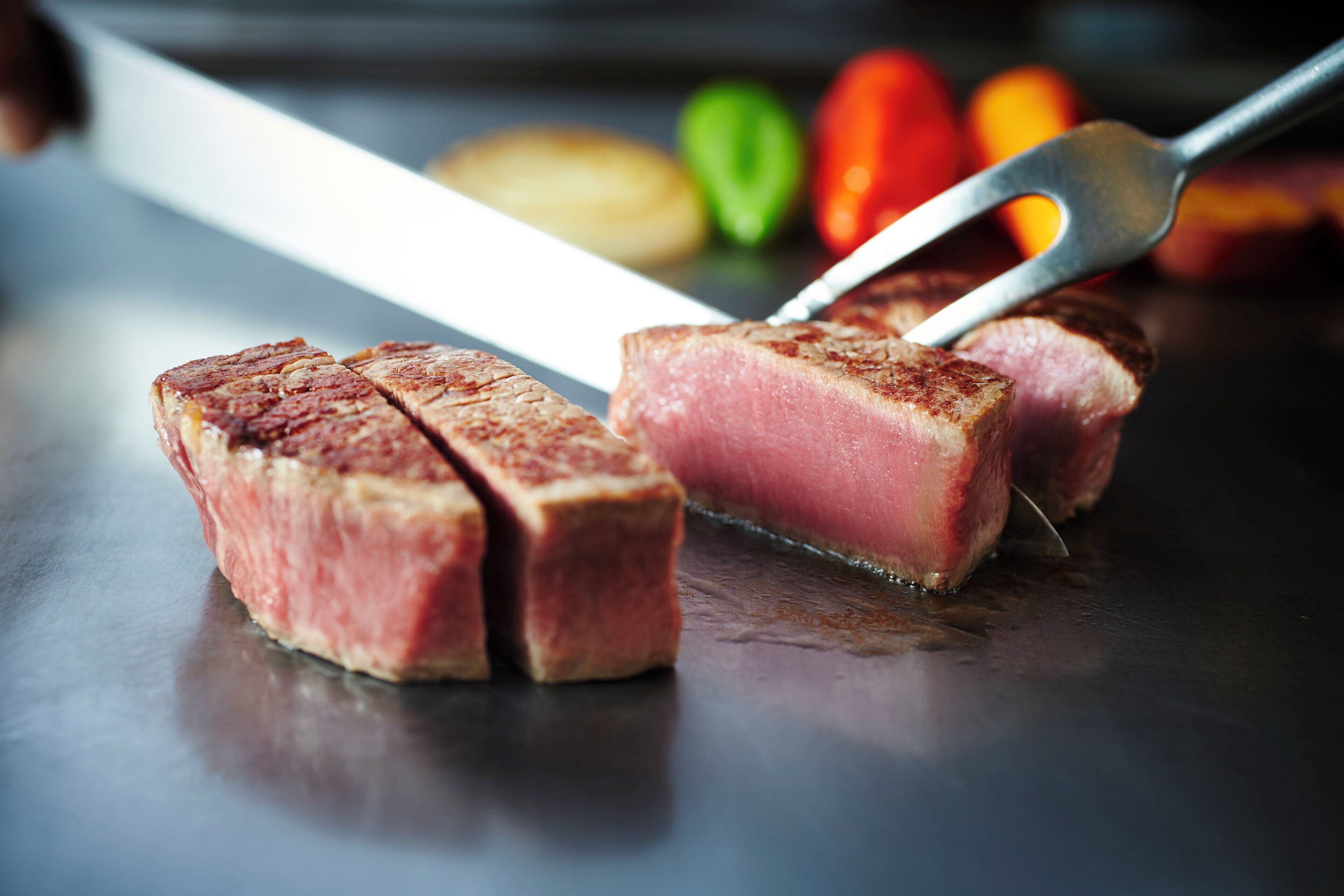 A steak being sliced on a cutting board.