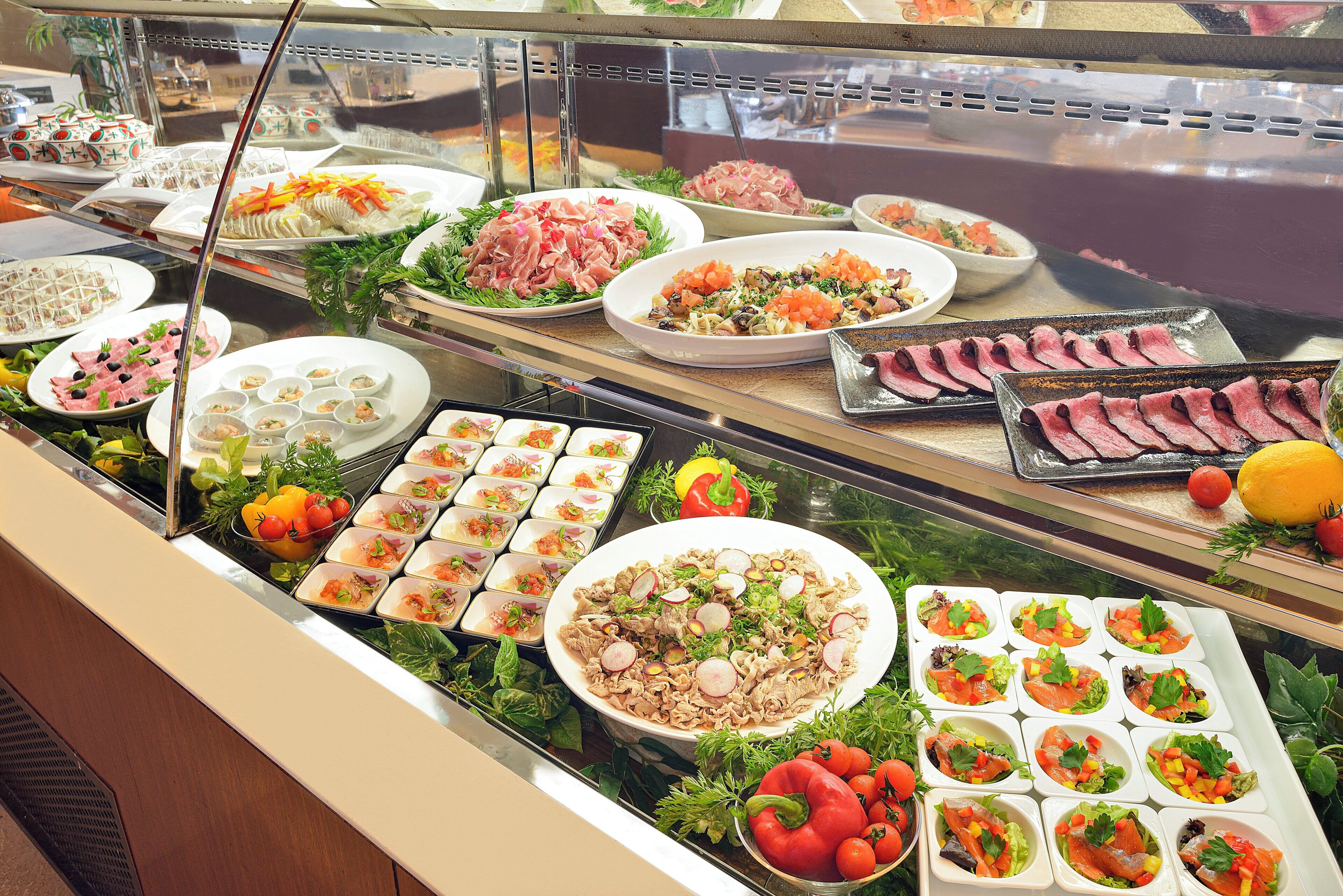 A buffet with various food options including salads, meats, and appetizers.