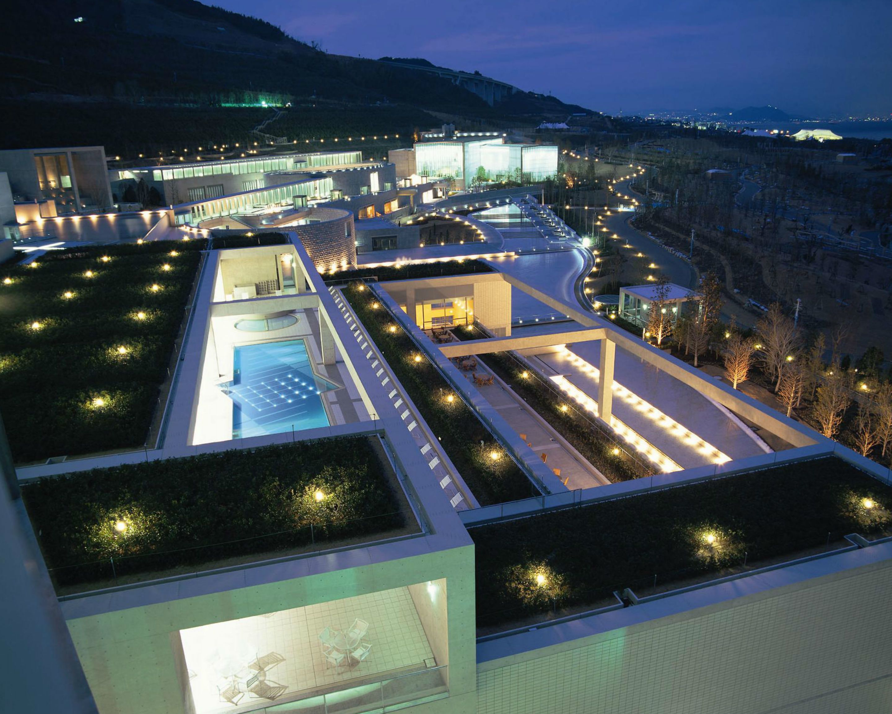 Un hotel moderno con piscina sul tetto, terrazze curate e vista sul paesaggio circostante.