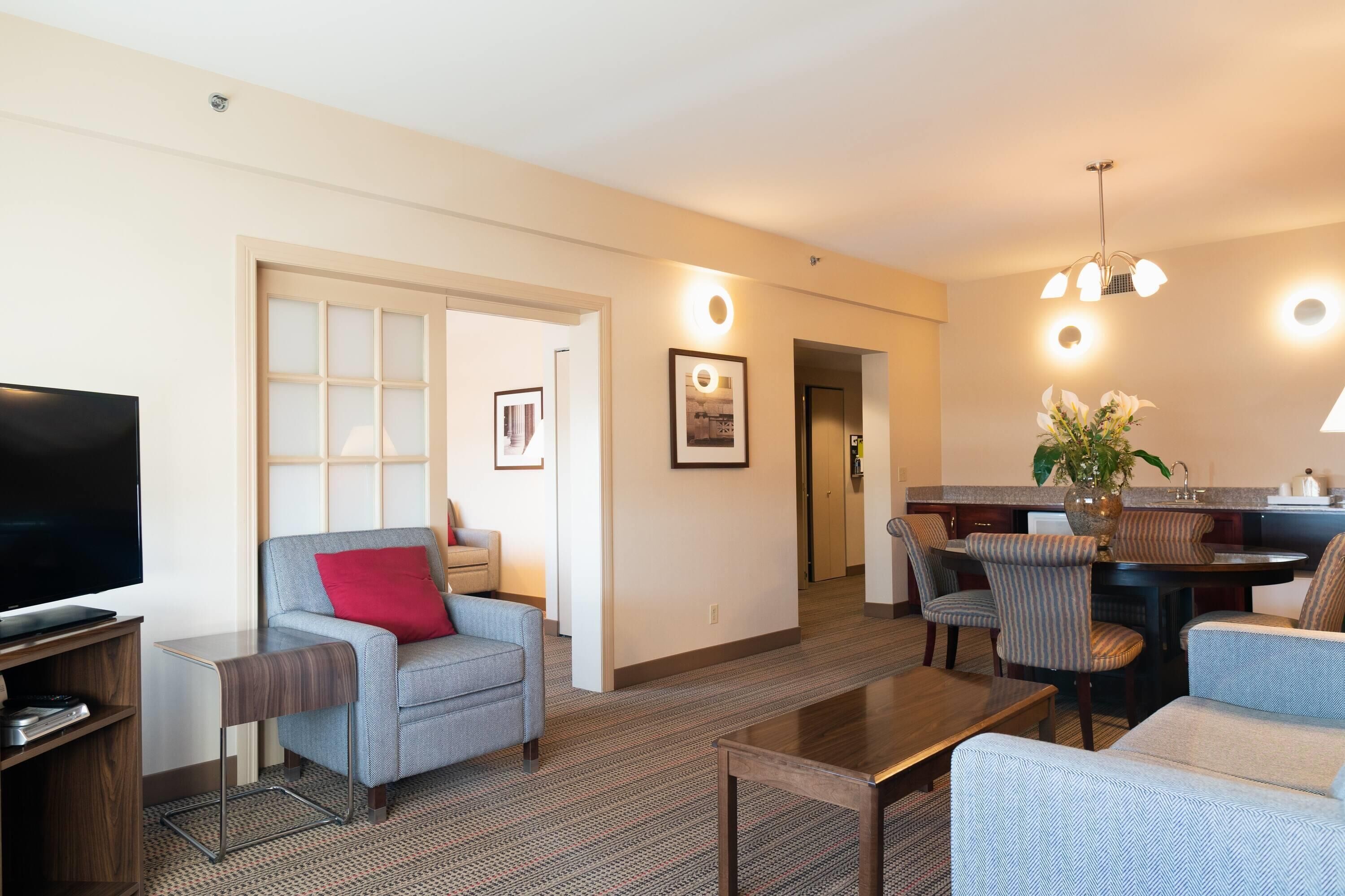 Una habitación de hotel moderna con sala de estar, comedor y cocina.