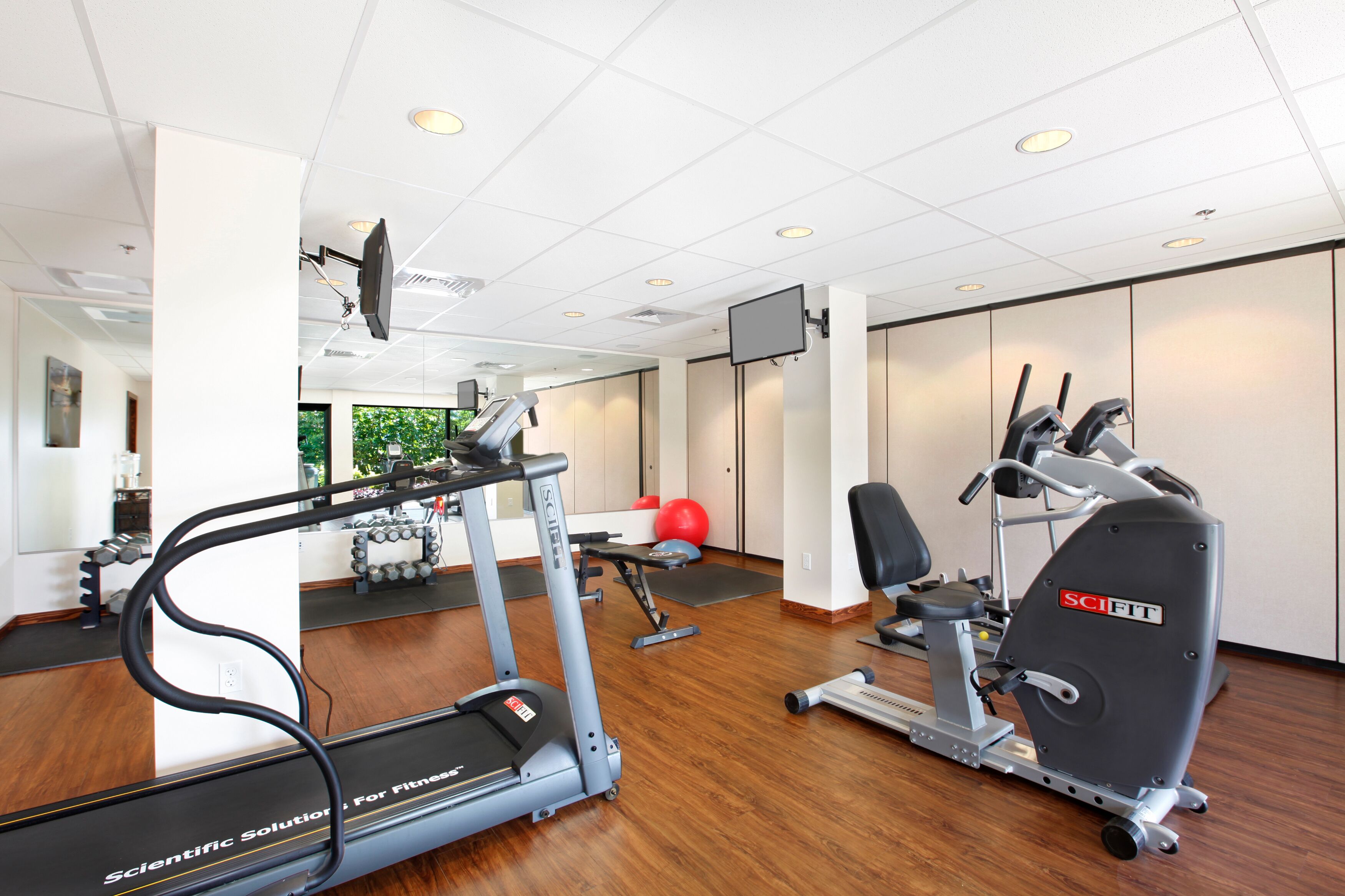 Ein Fitnessstudio mit Laufbändern, Ergometer und Gewichten.