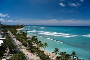 A coastal cityscape with a beach, palm trees, and a clear blue sky. - Aqua Aloha Surf Waikiki (Honolulu)