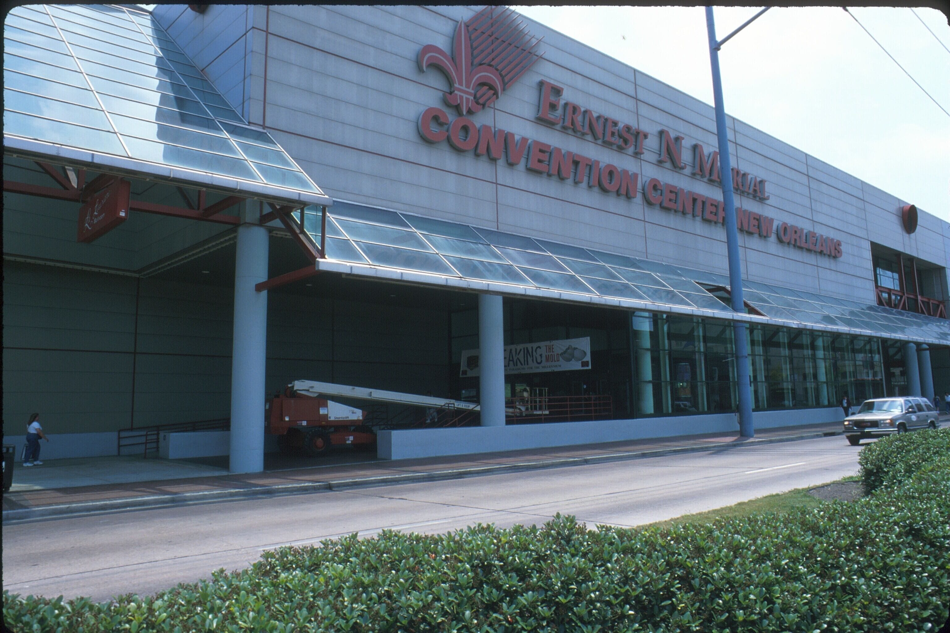 The Ernest N. Morial Convention Center in New Orleans with a modern glass facade and a large sign.