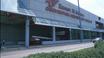 El Centro de Convenciones Ernest N. Morial en Nueva Orleans, con fachada de vidrio moderna y un letrero grande.