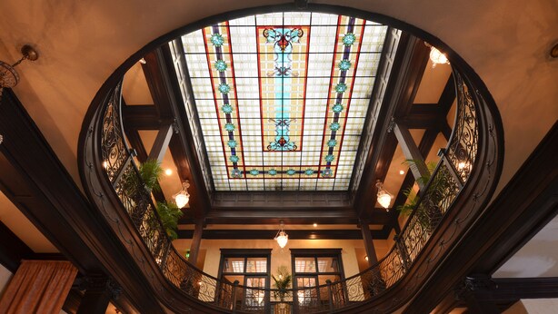 A grand, circular stained glass ceiling with intricate designs and a central decorative element. - Geiser Grand Hotel (Baker City)