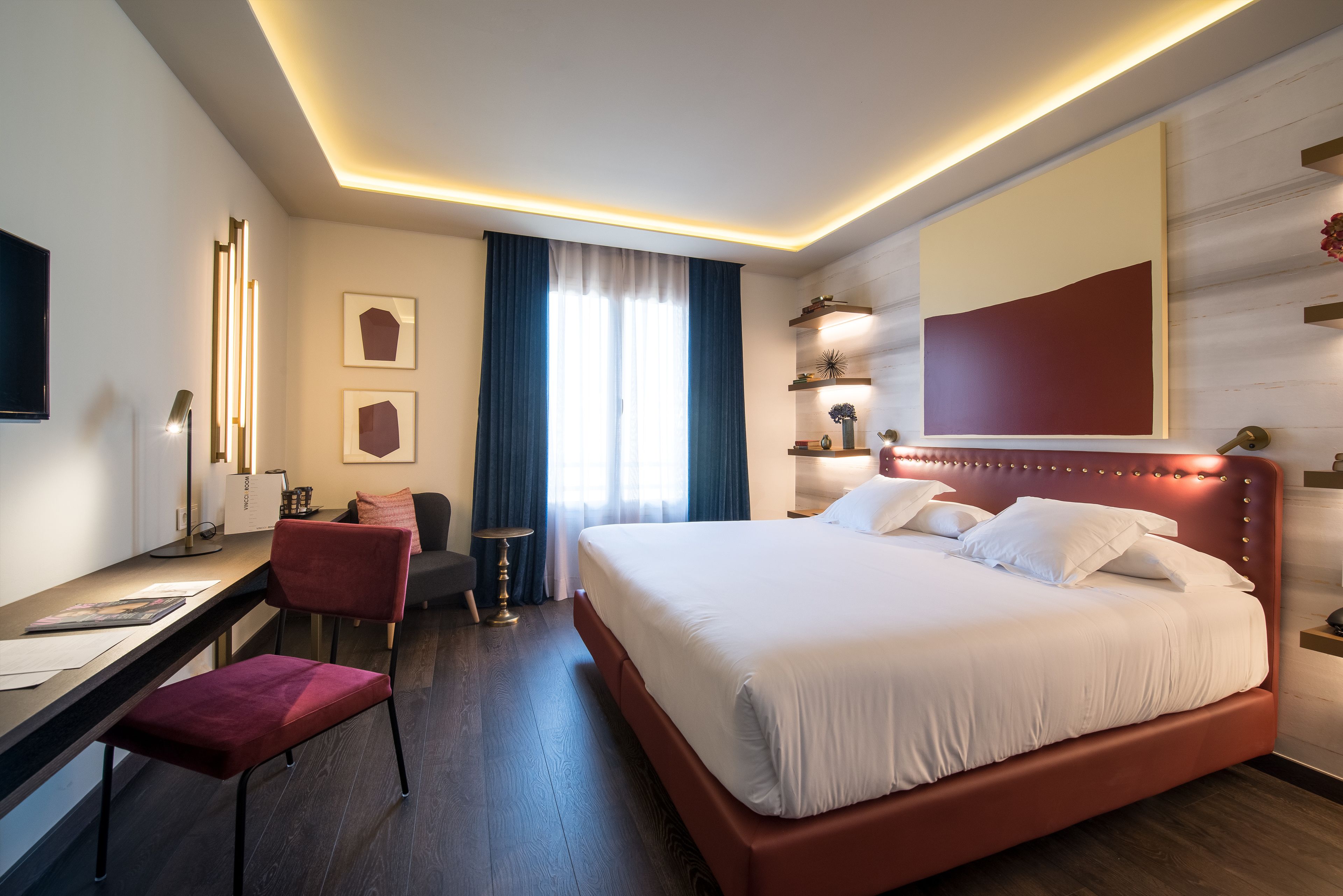 Habitació d'hotel moderna amb un llit gran, una taula i una cadira.