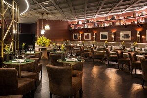 A restaurant with round tables, cushioned chairs, and a warm ambiance.