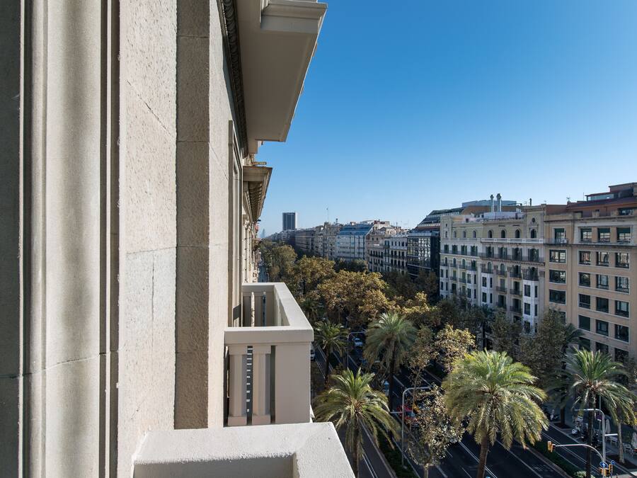 Un edificio alto con vistas despejadas del paisaje urbano, incluyendo palmeras y otros edificios.