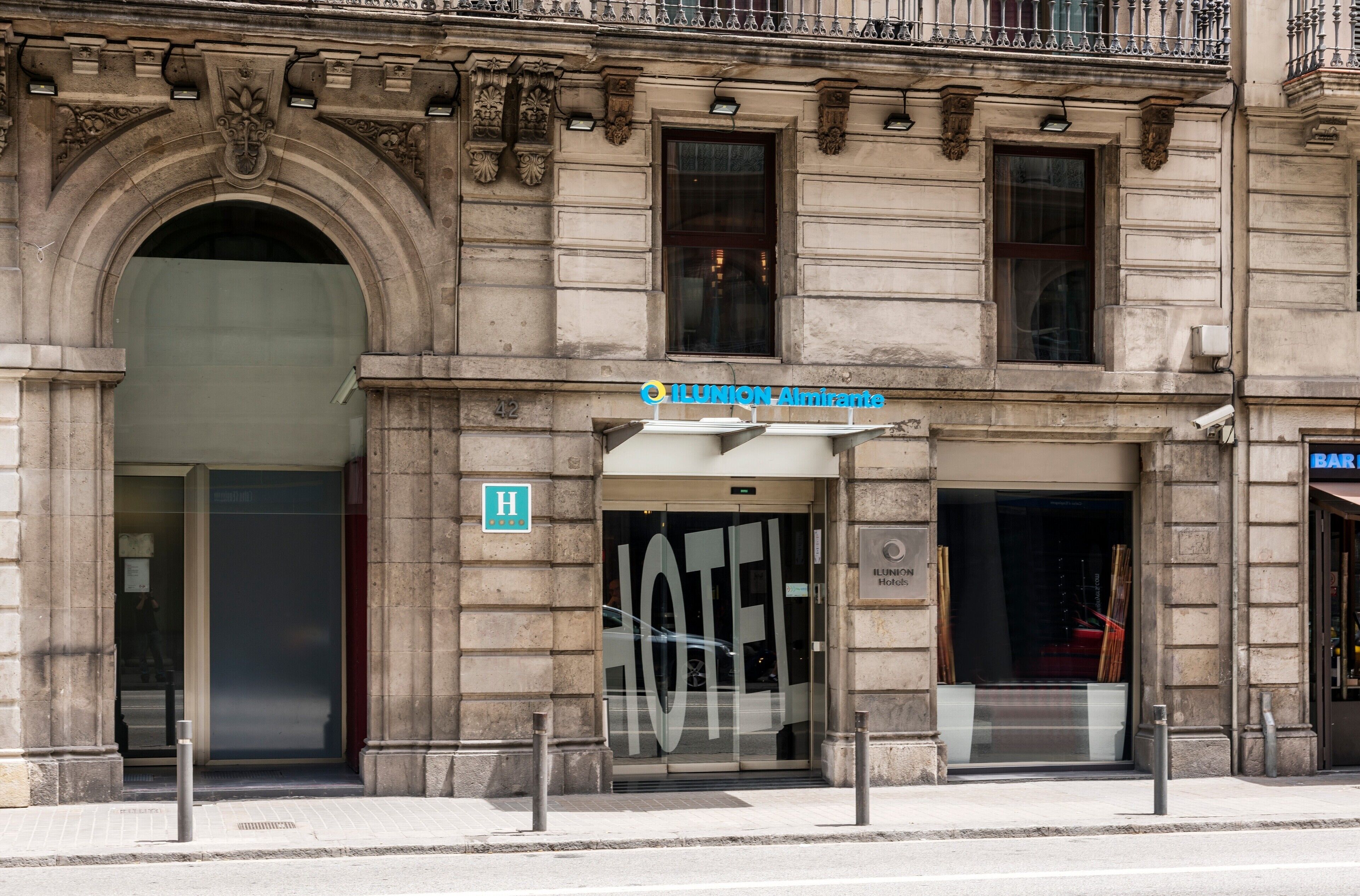 A hotel entrance with a large glass door, a sign for "IL UNION Almirante," and a visible handicap accessibility sign.