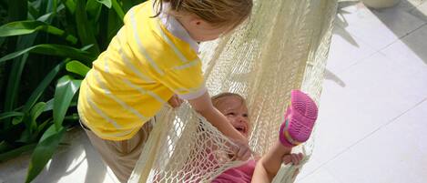 A child in a hammock with a pink shoe.