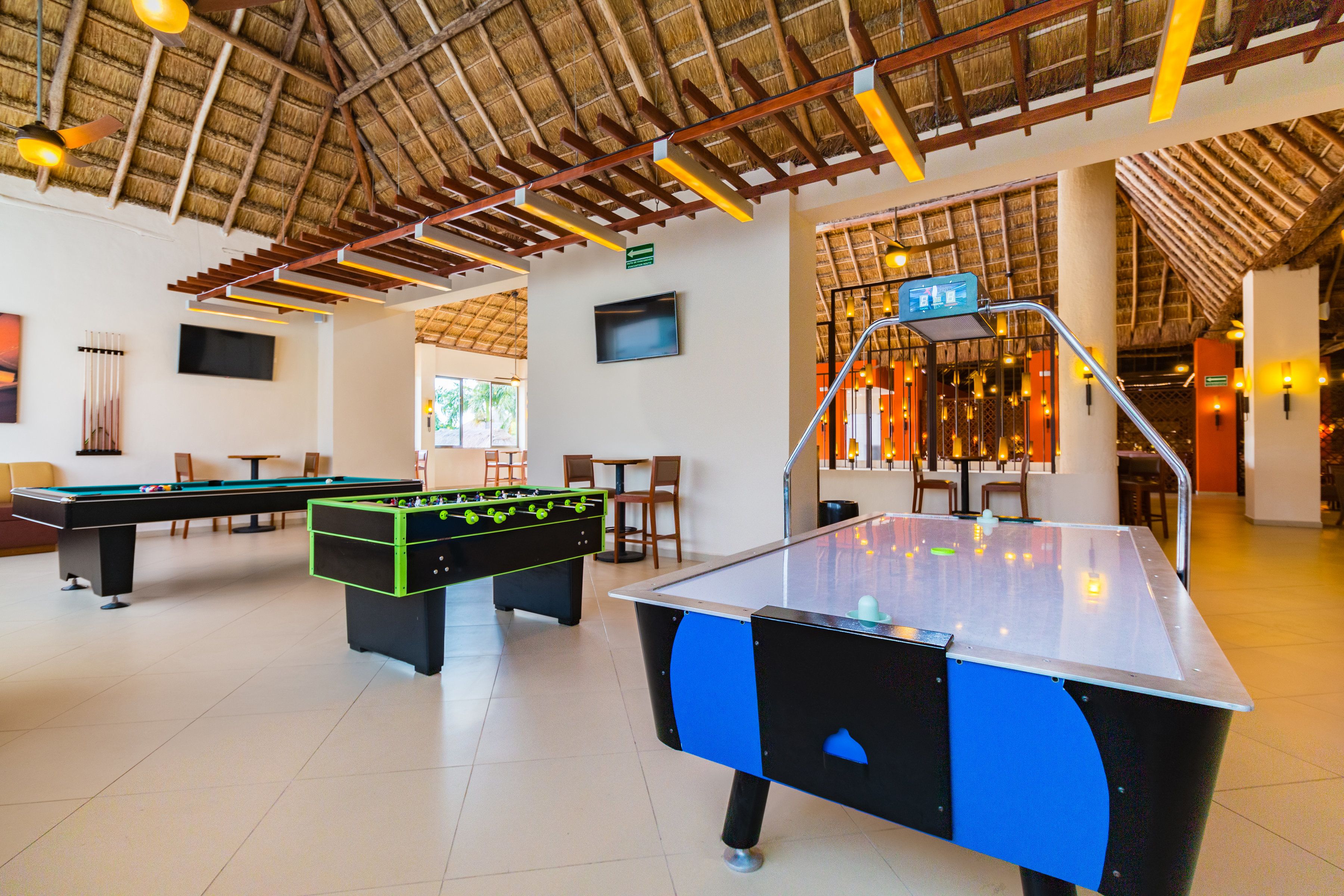 Un espace de loisirs équipé de tables de billard, d’un baby-foot et d’une table de ping-pong.