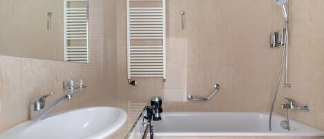 A modern bathroom with a bathtub, a sink, and a mirror.