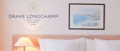 A hotel room with a bed, a nightstand with a lamp, and a framed picture on the wall.