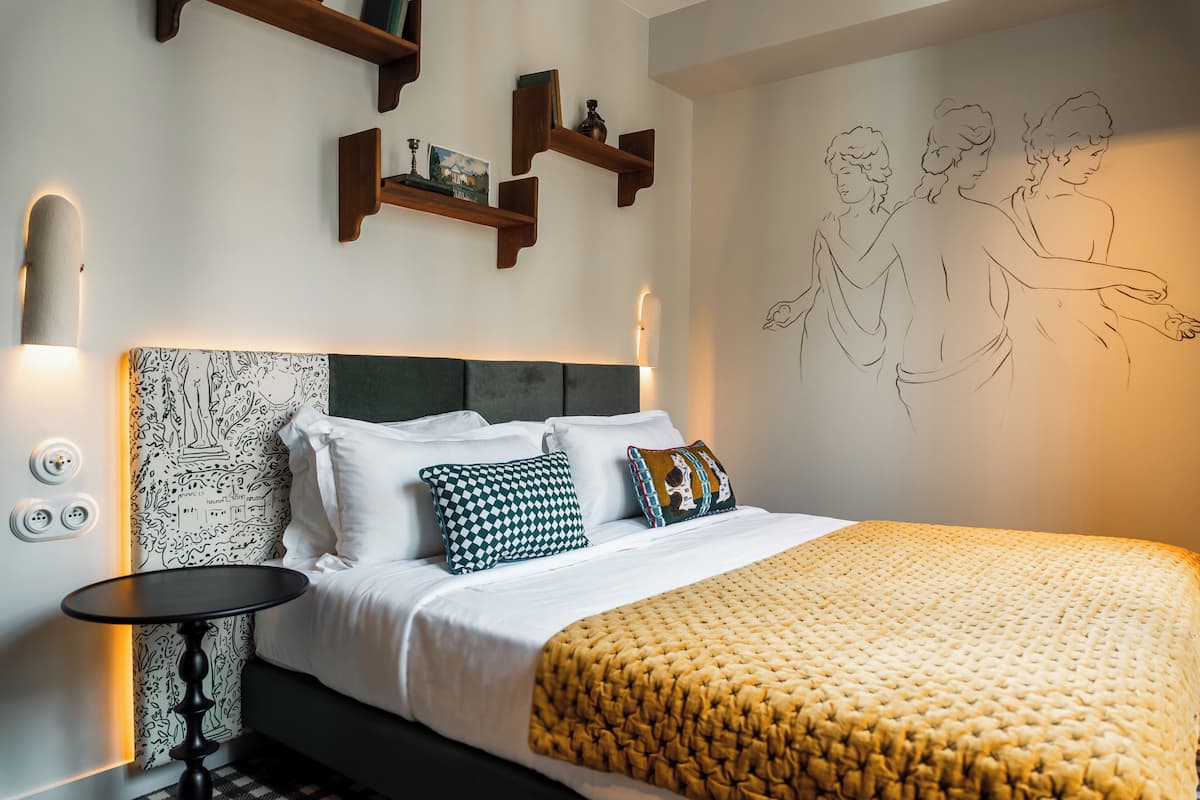 Ein ordentlich eingerichtetes Schlafzimmer mit einem Bett, Nachttisch und Wandregalen.