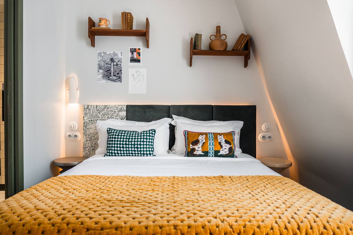 A neatly arranged bedroom with a bed, two bedside tables, and a headboard.