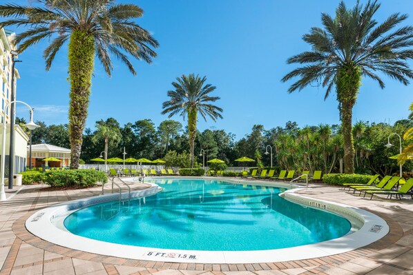 Una piscina al aire libre, sombrillas, tumbonas