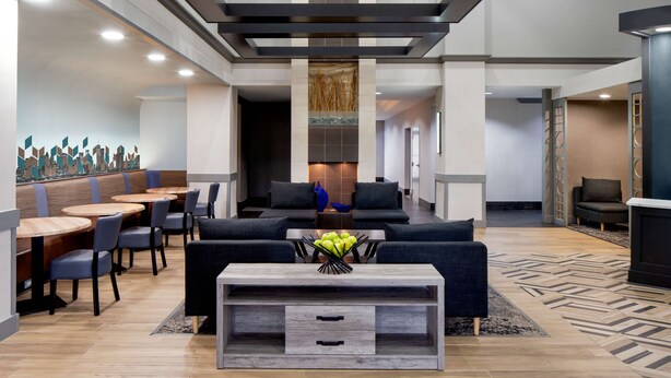 A modern lobby with seating areas, a coffee table with fruit, and a decorative wall. - Hyatt Place Fair Lawn Paramus (Fair Lawn)