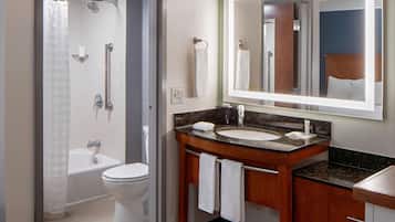 A modern bathroom with a shower, toilet, sink, and vanity.