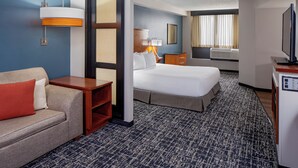 A hotel room with a bed, a sofa, a desk, a TV, and a window with curtains. - Hyatt Place Fair Lawn Paramus (Fair Lawn)