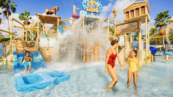 Un parc aquatique doté d’une grande fontaine, de toboggans et d’une enseigne « Bienvenue ».